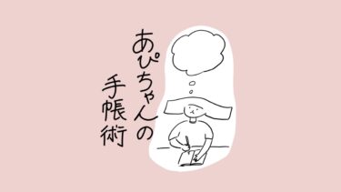 あぴちゃんが手帳にペンで何かを書きながら考えている場面。頭上に横長の四角い髪が特徴的なあぴちゃんが、空の思考バブルを浮かべている。タイトル文字「あぴちゃんの手帳術」が左側に書かれている。